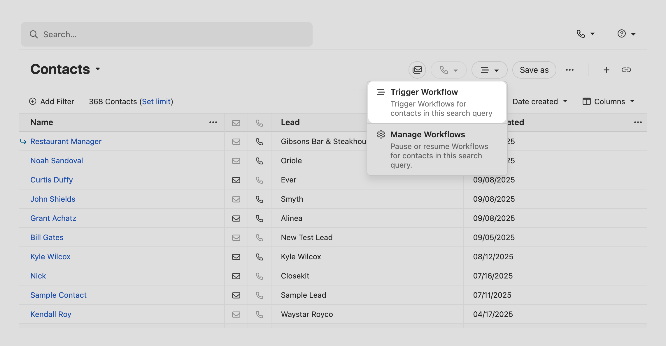 Contacts list view with a dropdown showing Trigger Workflow and Manage Workflows options.